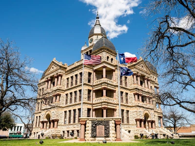 Parker County Courthouse in Weatherford, Texas with U.S. and Texas flags in front