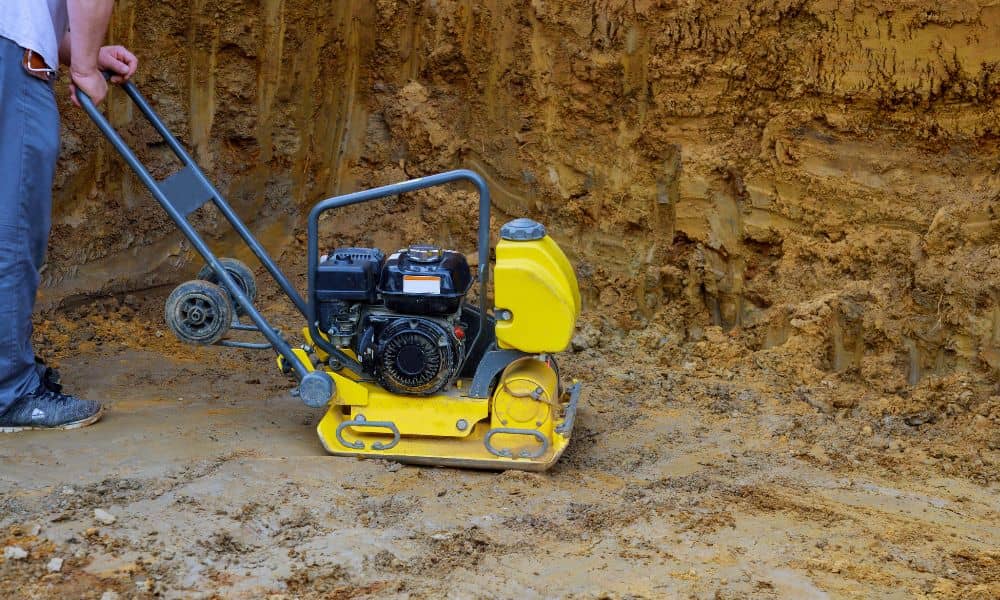 Worker using soil compaction equipment at a construction site in Weatherford